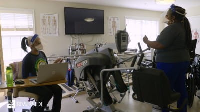 Two African American women sitting in a room with medical equipment