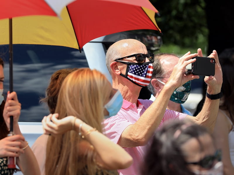 Man in crowd taking picture of James Hall