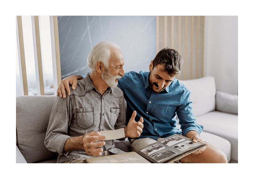 Senior man showing photographs to his son