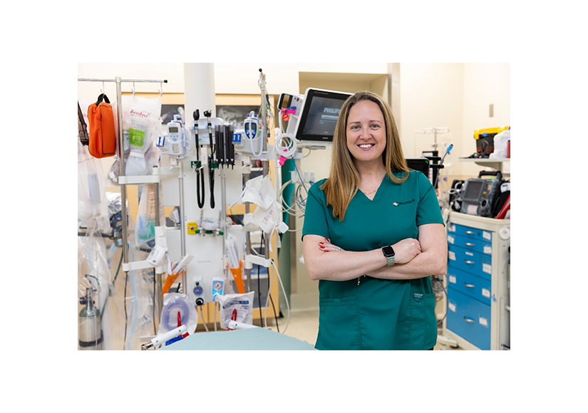 woman in green scrubs smiling standing in trauma bay 