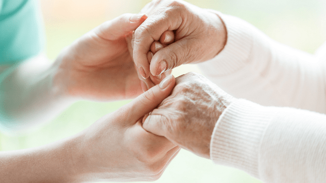image of hospital employee holding hands with elderly women