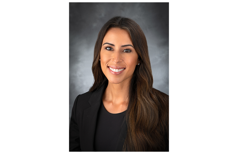 Woman in black shirt and jacket and brown hair smiling