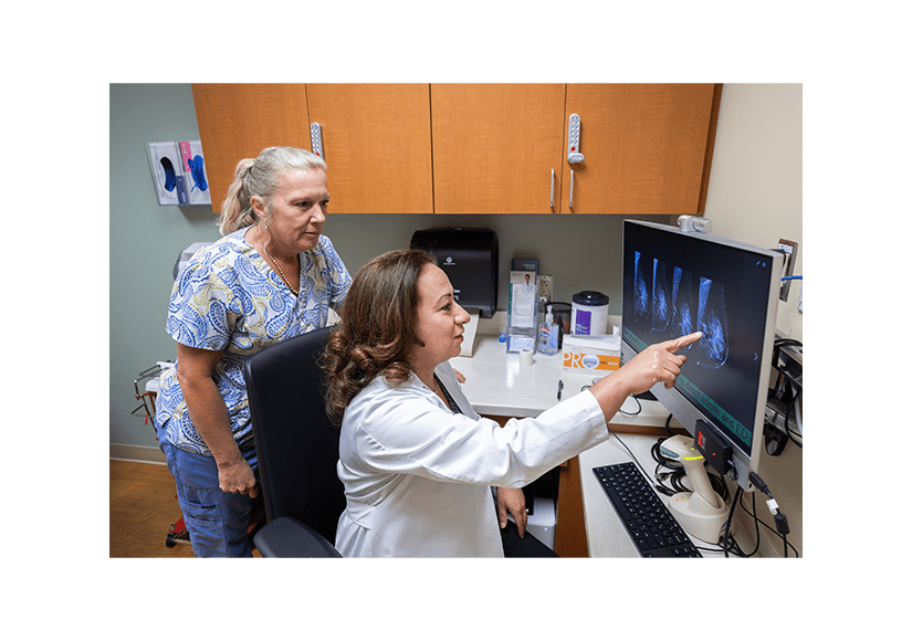 Healthcare professionals reviewing breast imaging scans on a computer monitor in a clinical setting as part of the POWER breast clinical trial.