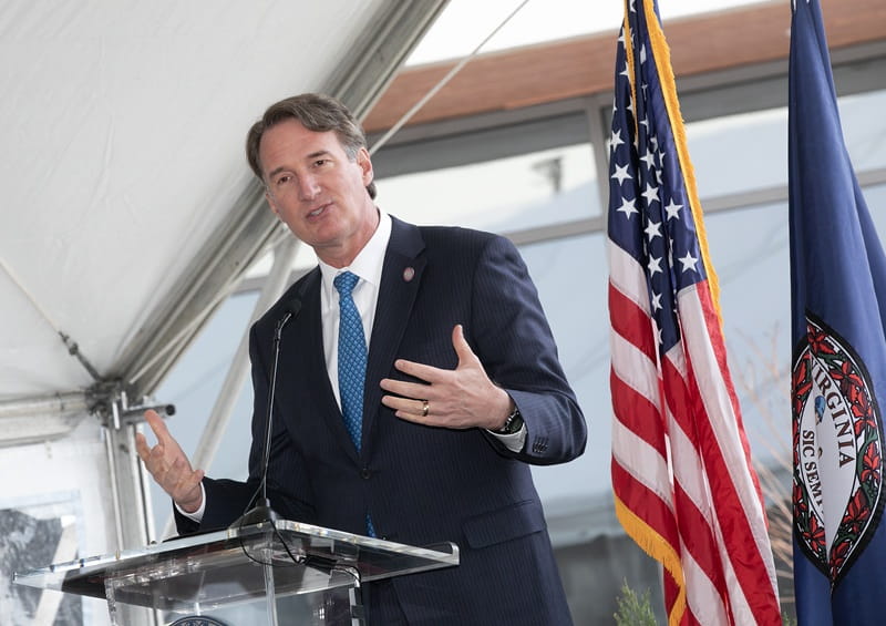 Glenn Youngkin speaking infront of flag
