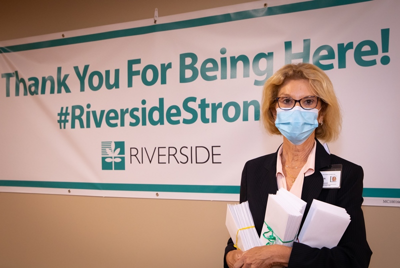 Woman in front of banner holding gift envelopes