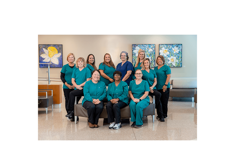 Team of nurses smiling in green scrubs