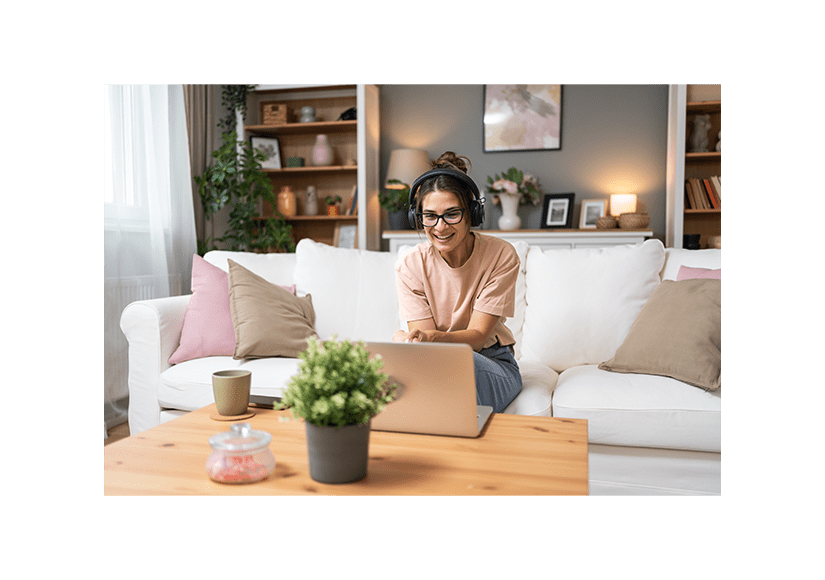 woman in glasses sitting at computer with headphones on 