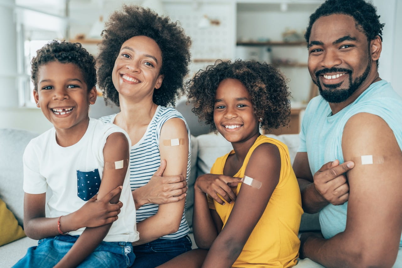 African American Family smiling with band aids on their arms