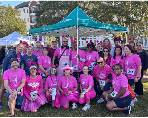 Riverside Health team members participating in a community charity walk event, showing teamwork, community engagement and support for breast cancer awareness.