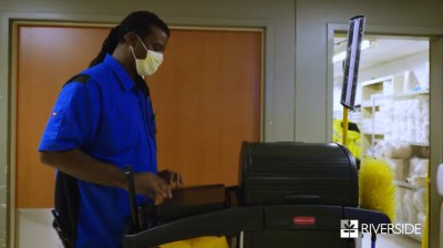 African American Man in a blue shirt and yellow mask typing