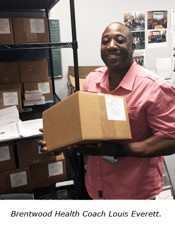Louis Everett, Brentwood Health Coach at Riverside Health, holding a food box for the diabetic food insecurity support program.