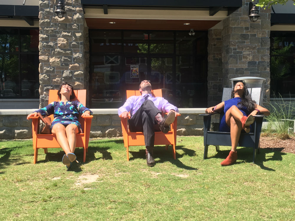 residents relaxing in the sun in adirondack chairs