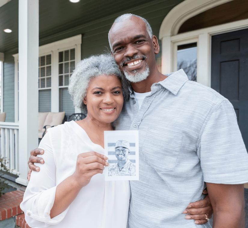 2 people holding a picture of military veterans