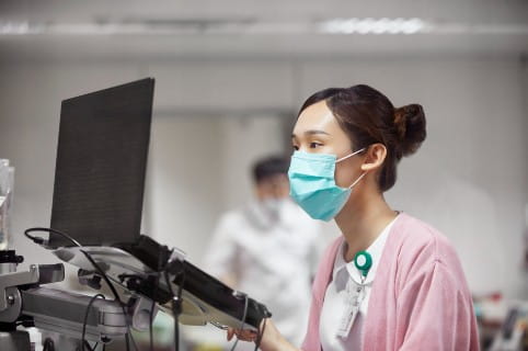 Nurse using laptop while making medical records