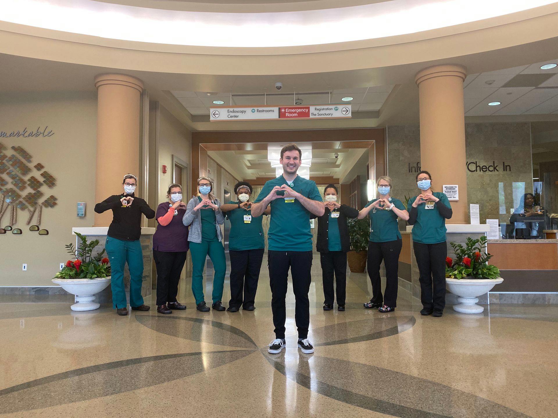 Riverside Team Members Hold Up Heart Hands in Gratitude