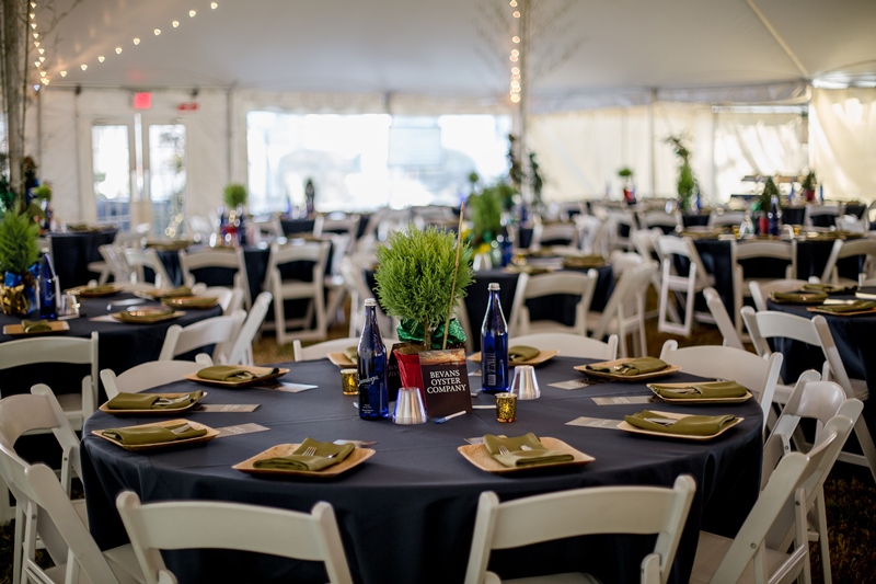 Image of empty tables before the riverside tree of lights event