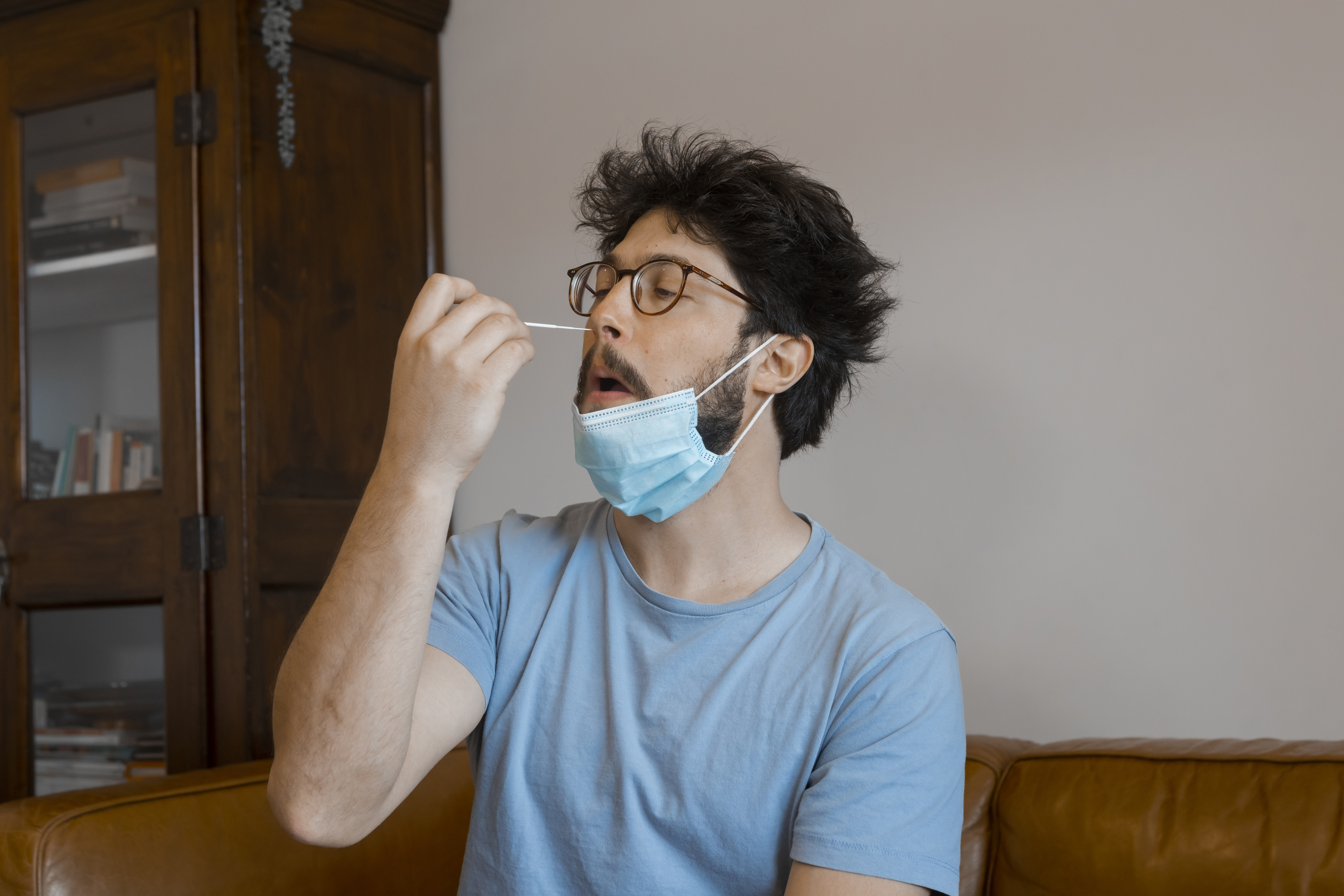 Caucasian man testing himself for covid 19 at home