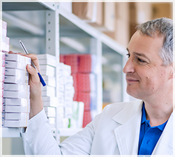 Pharmacist perusing medication shelves