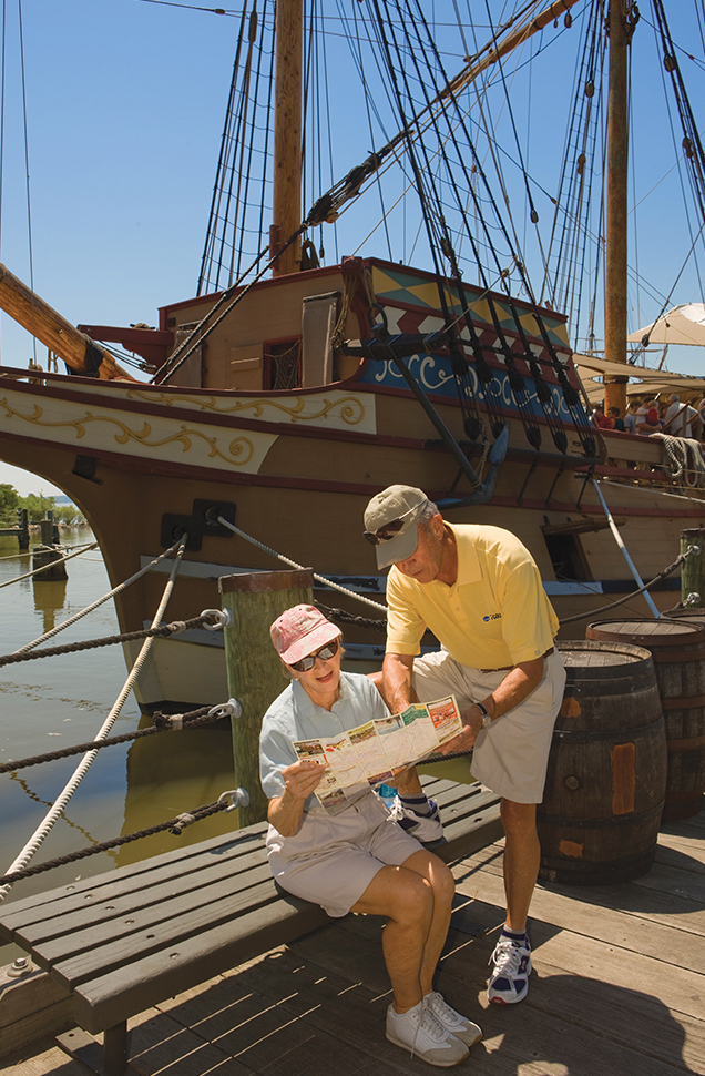 Seniors reading a pamphlet by a ship