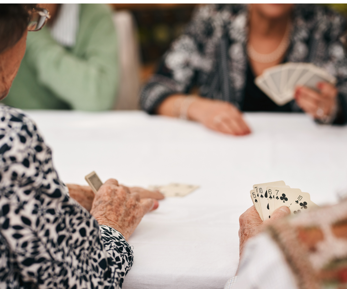 Group of older women playing a card game at a table