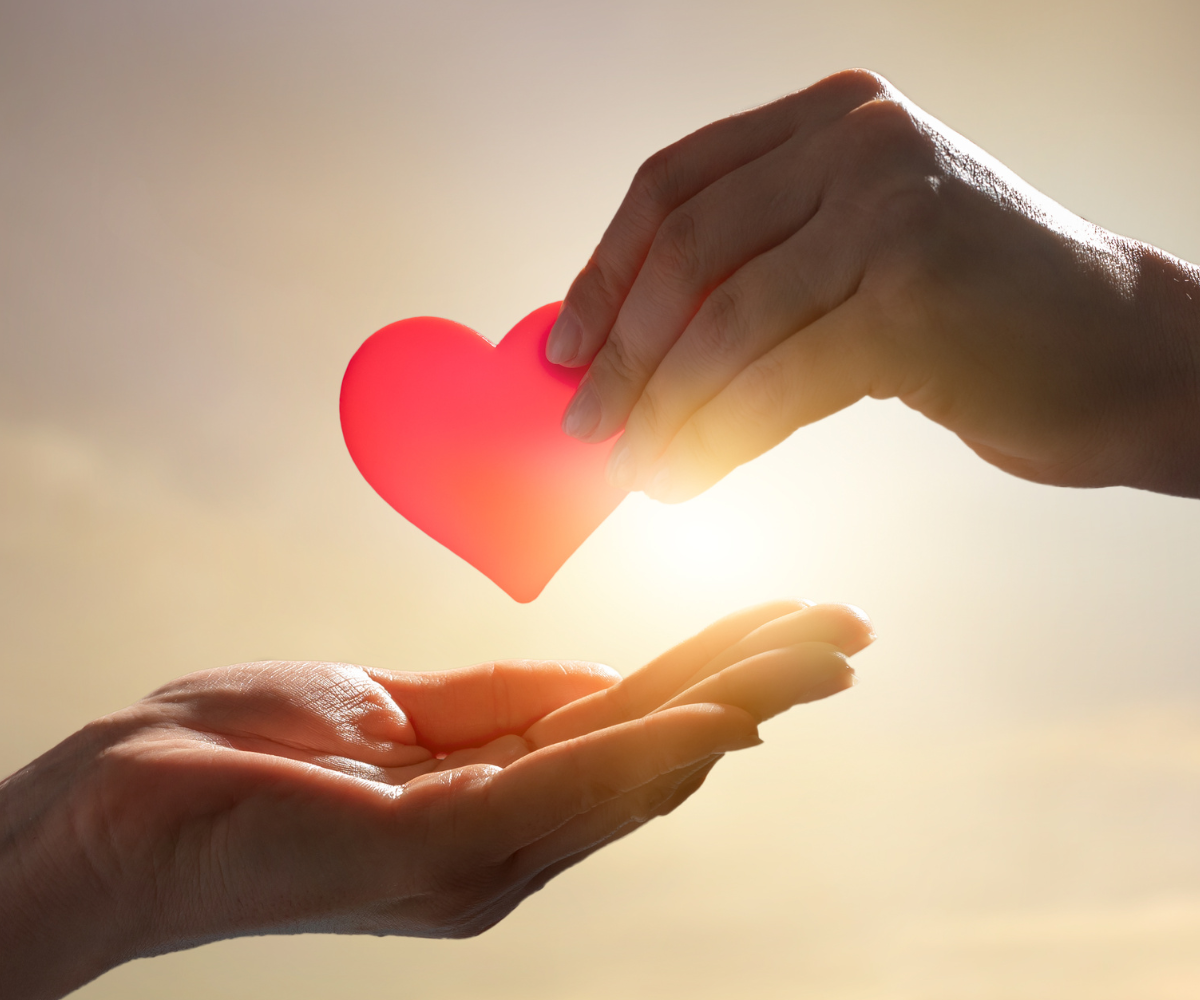 Hand passing a heart icon to another hand