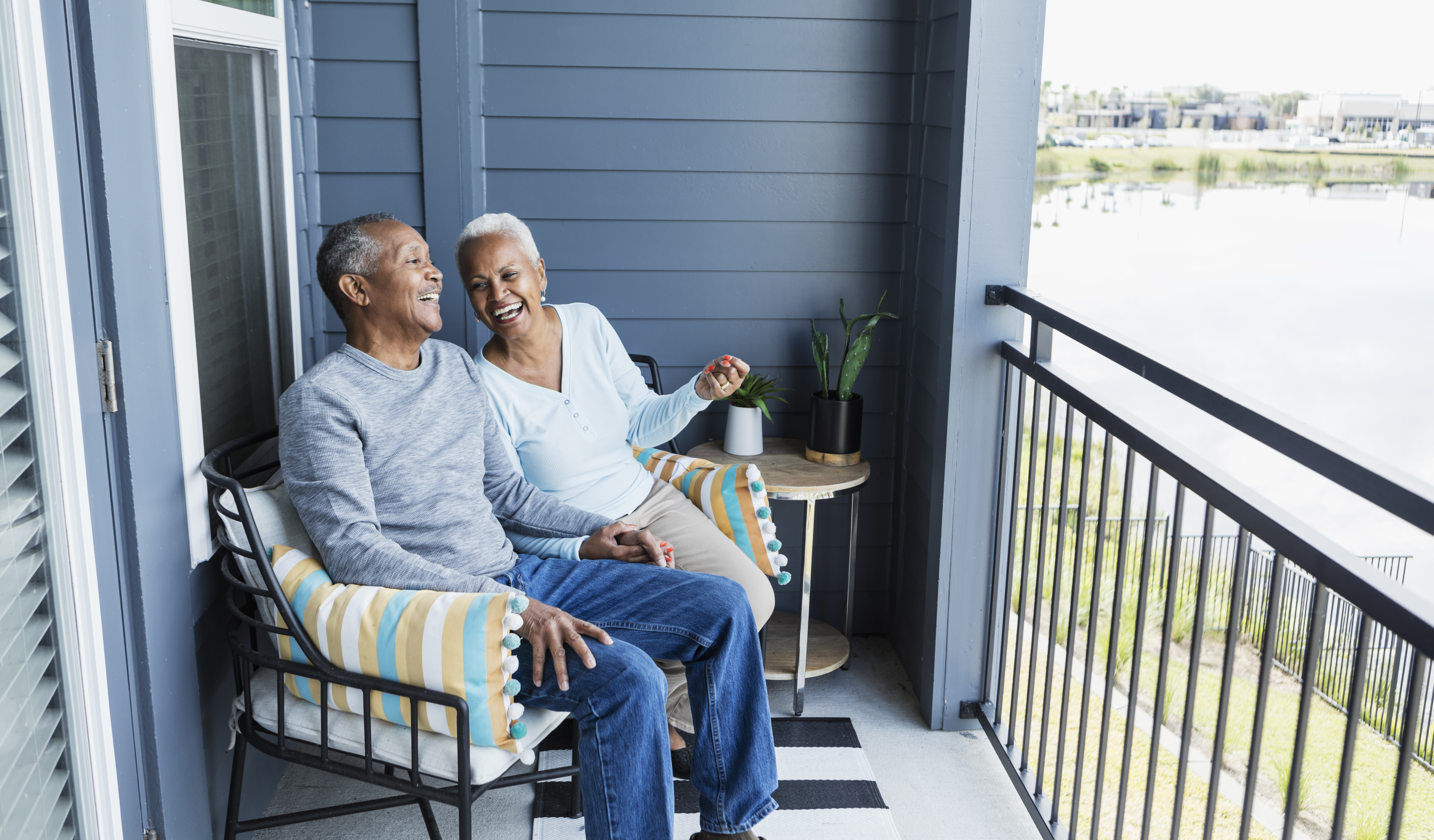 Older Black Couple sitting on their porch laughing