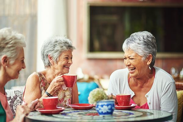 Older ladies sitting around a table laughing