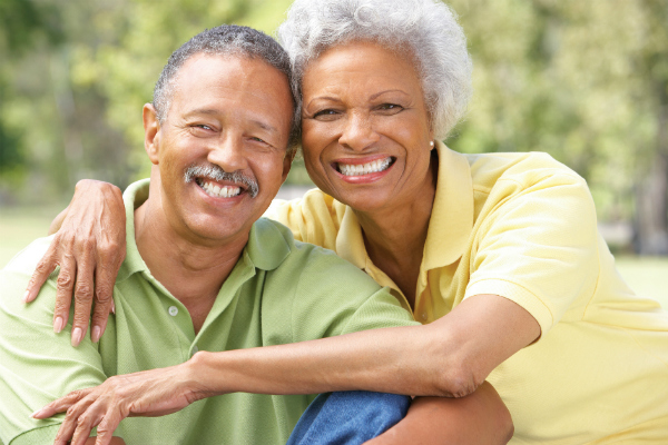 Older black woman with arms around older black man