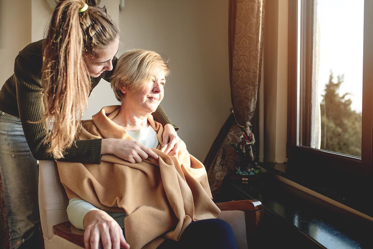 Young woman caring for a senior woman.