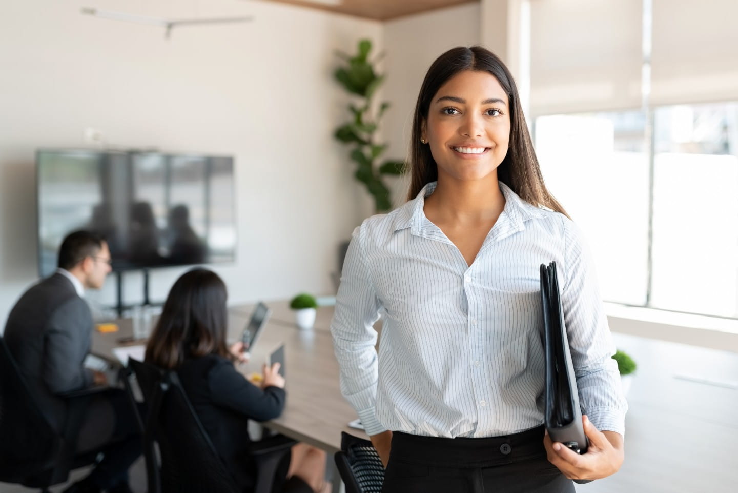 Young woman dressed in business casual attire smiling at the camera