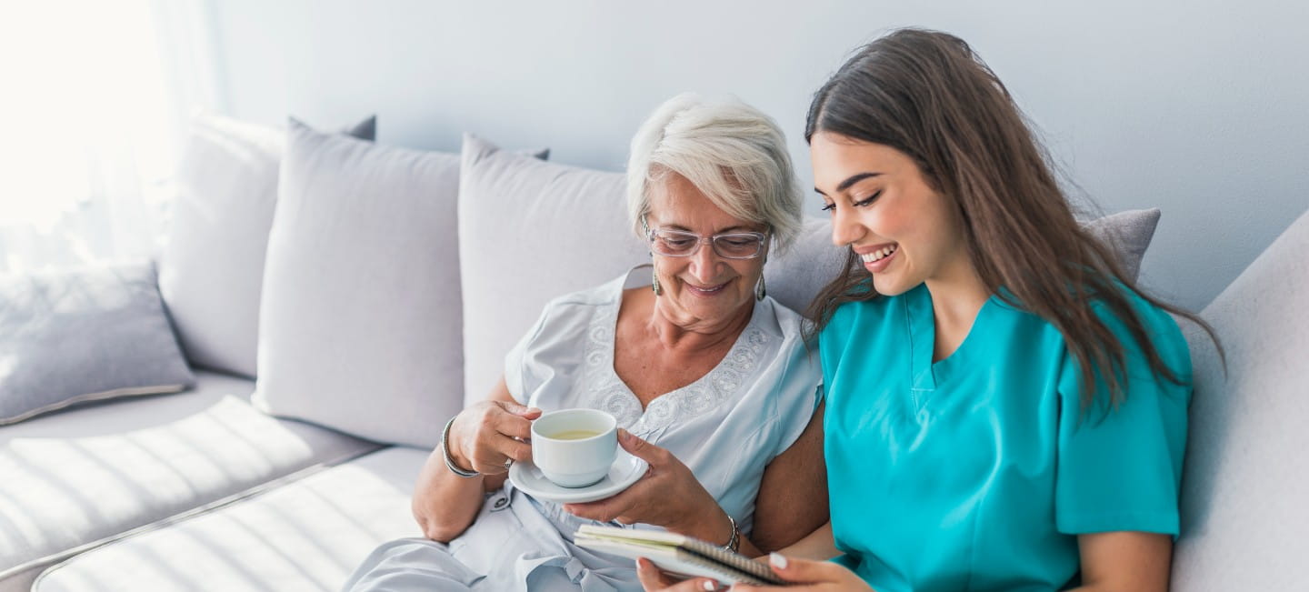 older woman sitting on the couch with a cup of coffee 