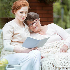 Entering hospice does not have to be seen as a negative. Nurse reading to hospice resident