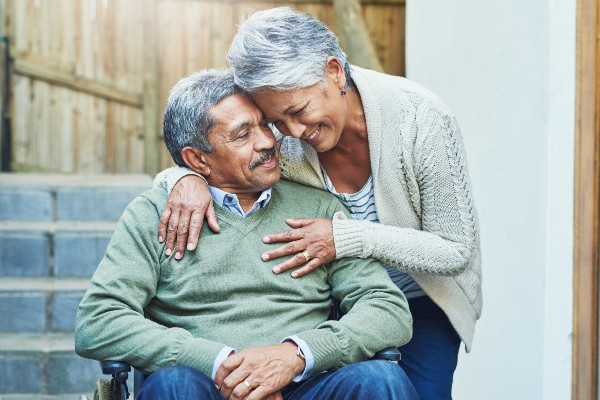 Older Black couple hugging 