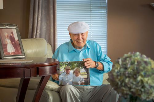 Sam Pinello holding a photo of Mr and Mrs Pinello