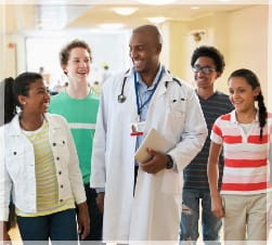 African American Provider with a number of students in a hallway