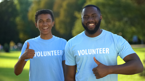 Join Our Volunteer Community Two males showing thumbs up, nature preservation volunteering