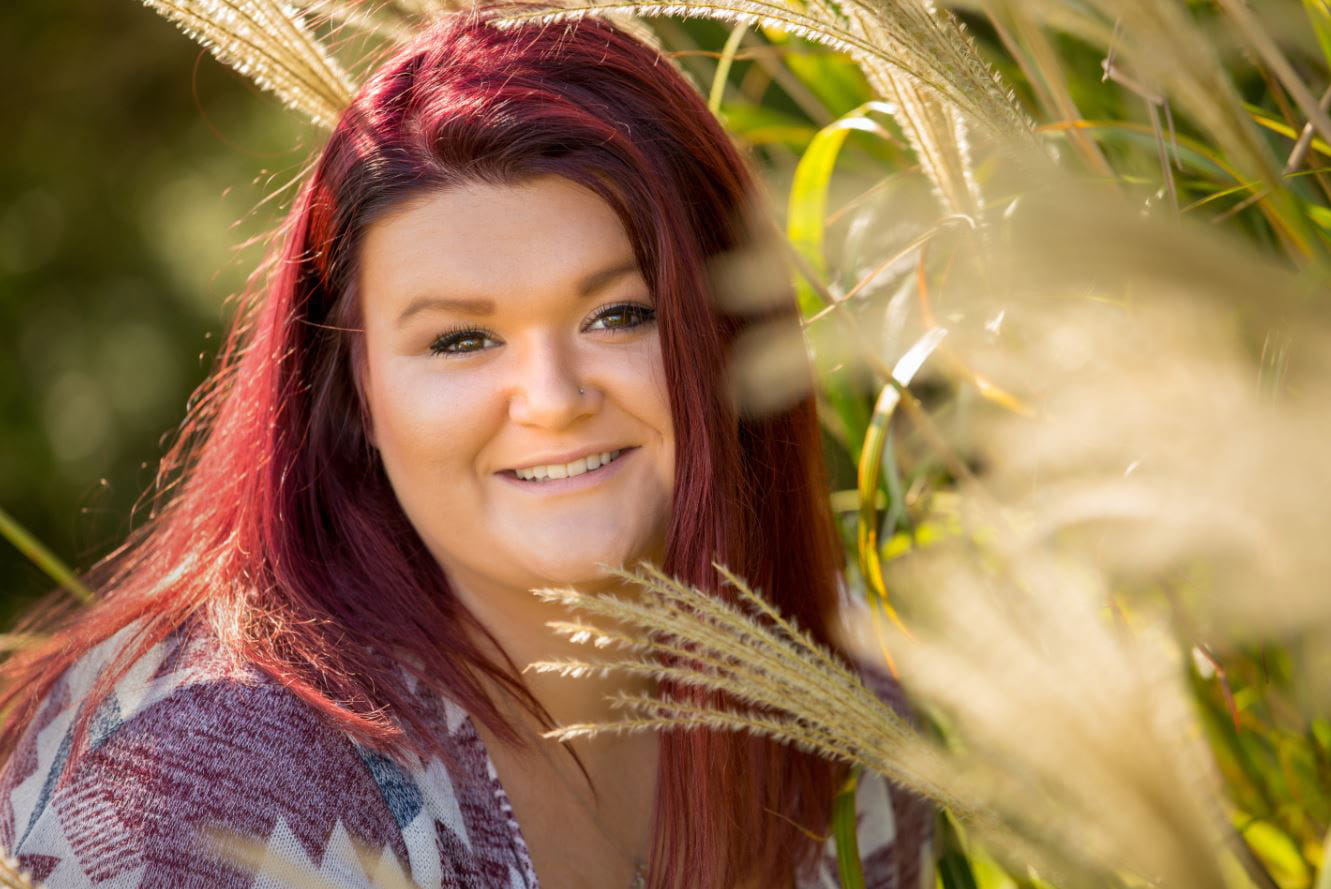 Rachel Fluhart sitting in wild grass