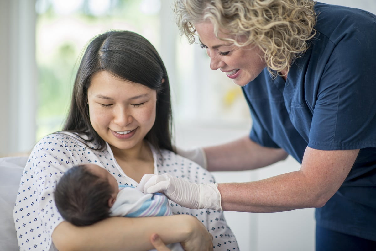 woman holding her baby in a hospital setting