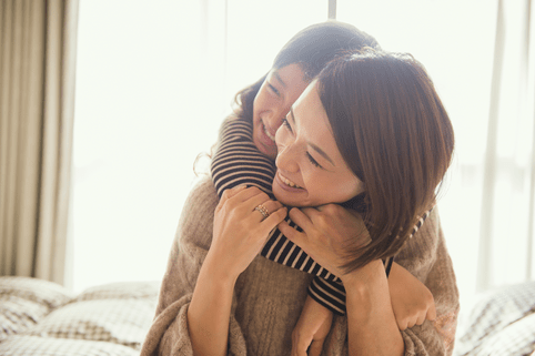 Care close to home, rooted where you are Mother and daughter having fun time in bed room