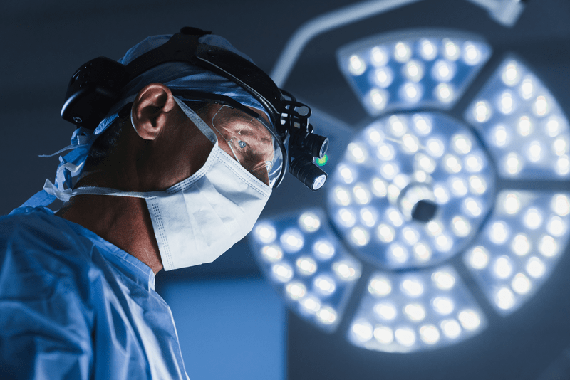 Surgery operation. Senior male surgeon in operating room with surgery equipment
