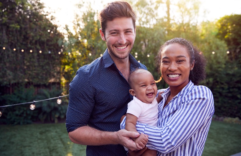 Portrait Of Family With Baby Son At Home Outdoors In Garden 