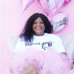African American Woman smiling in front of a pink wall with a light pink tutu on
