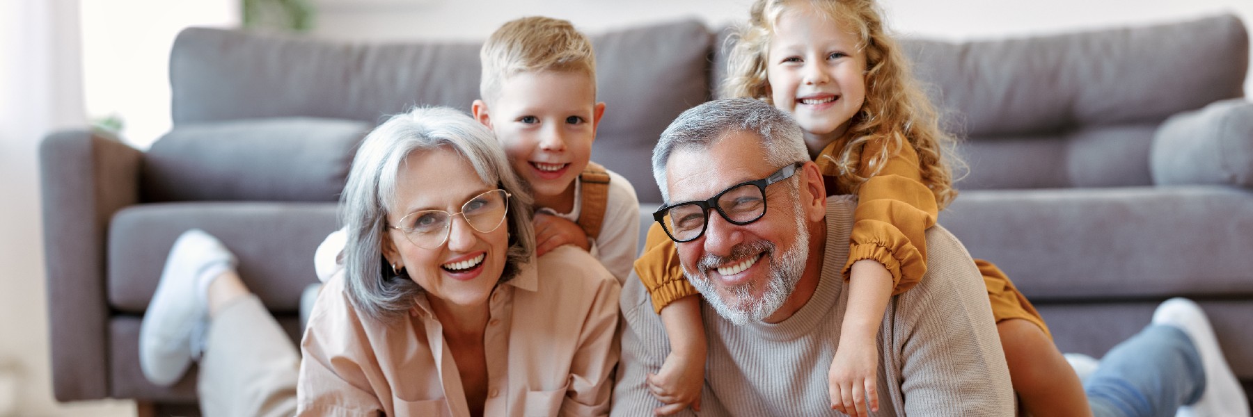 Beautiful cheerful family two cute little kids hugging with positive senior grandparents on fl