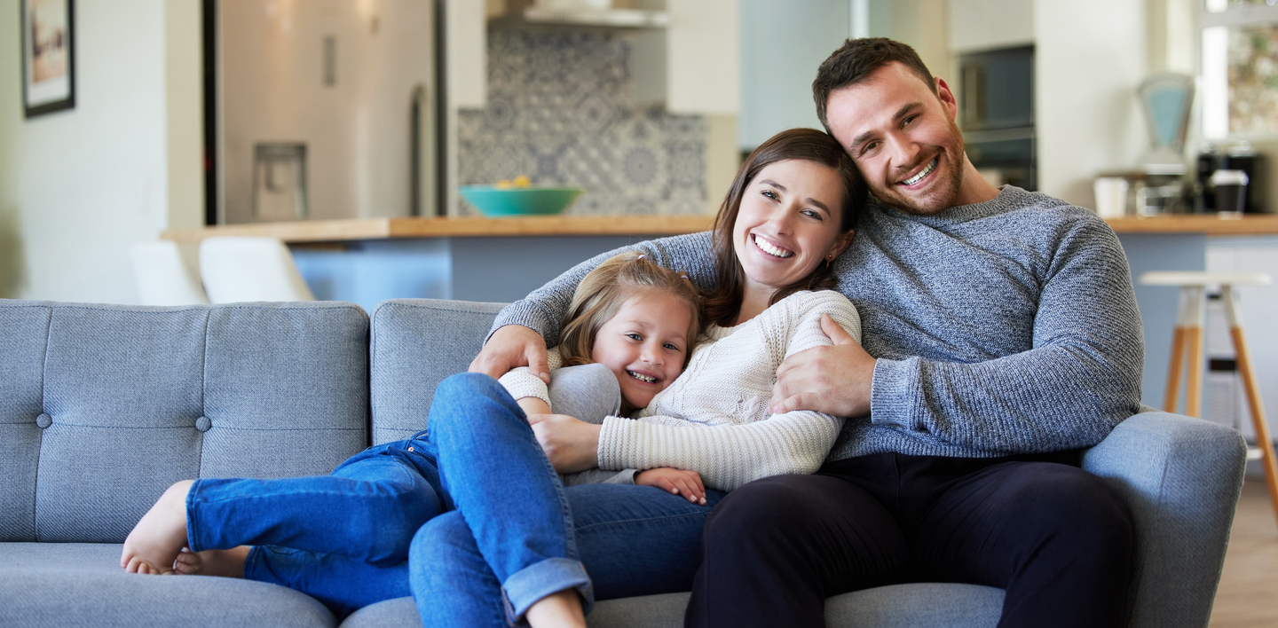 Shot of a young family relaxing on the couch at home
