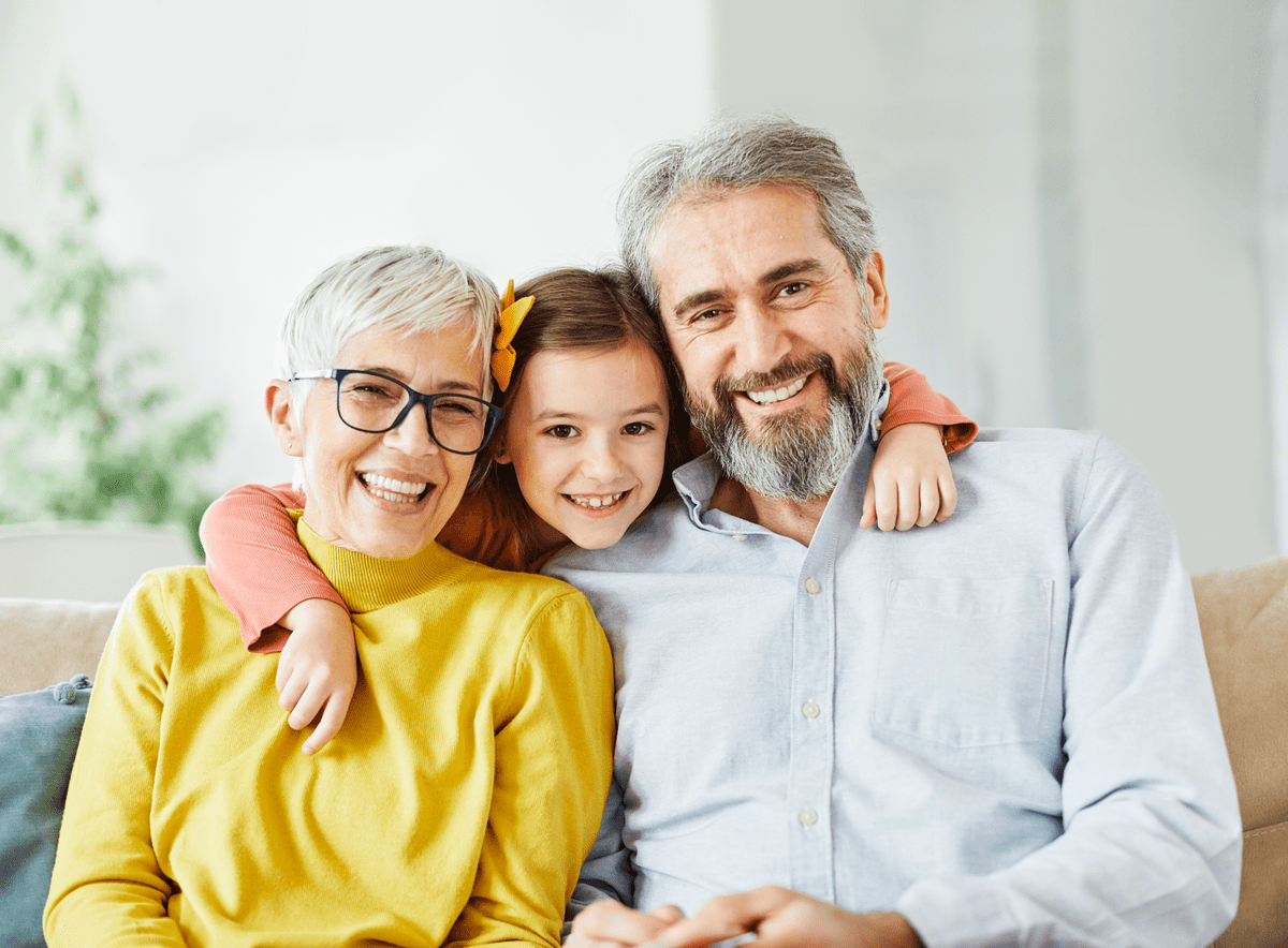 Portrait of grandparents and granddaughter having fun together at home