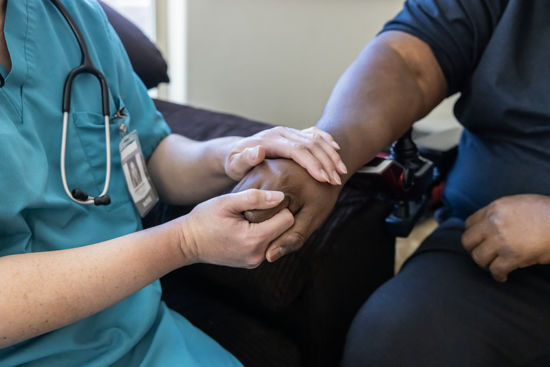 Support Services A nurse caring for a patient in a wheel chair at home