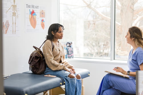 Female doctor talking with young patient