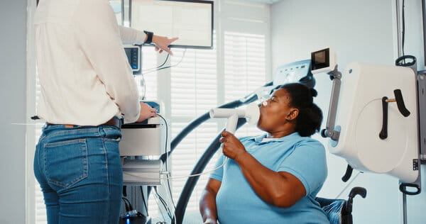 Doctor performing pulmonary function test of female patient, spirometry assessment in medical hospital and lung healthcare. Covid pneumonia or asthma exam of respiratory system breathing equipment.