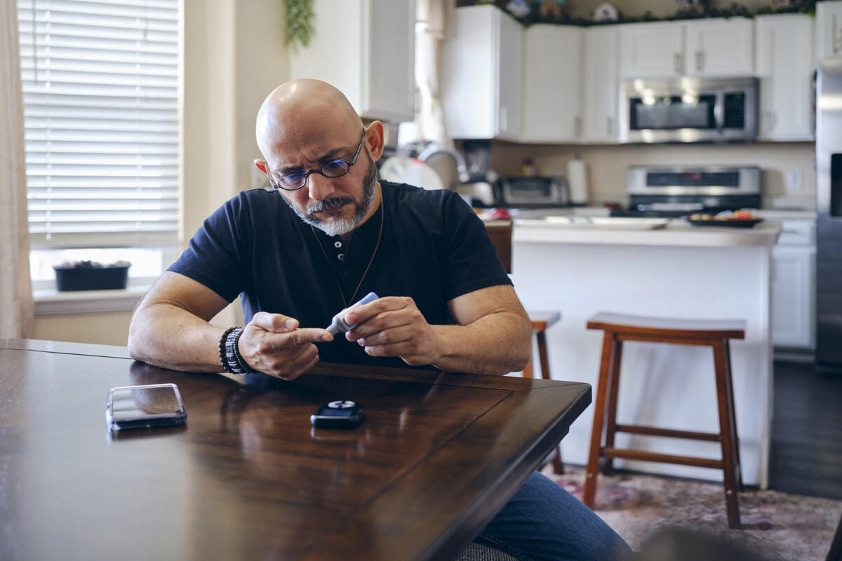 A Mature Man in a Home Checking His Blood Sugar 