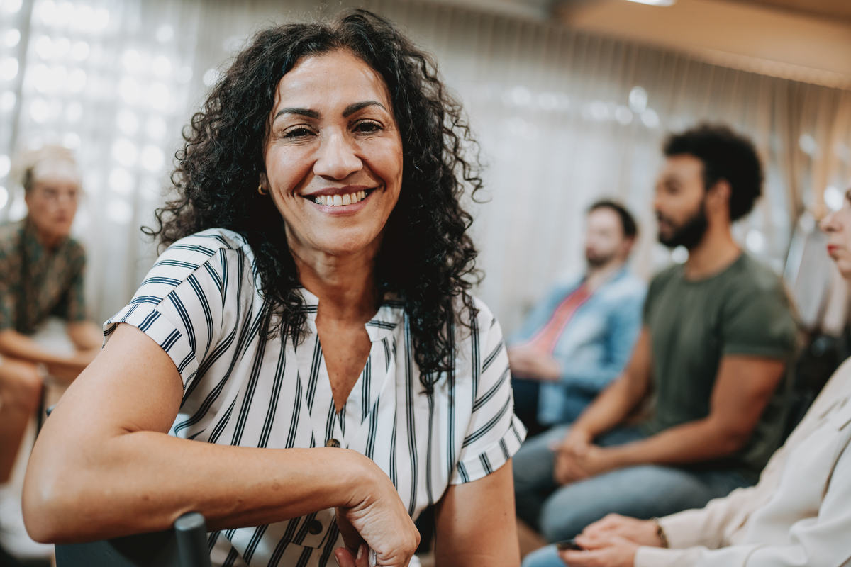 Portrait of a smiling woman in group therapy
